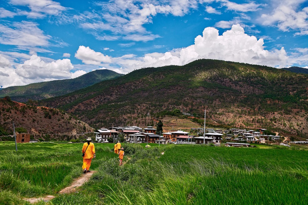 Membros de um grupo religioso no caminho do monastério de Chimi Lhakhang, no distrito de Punakha, no Butão — Foto: Poras Chaudhary/The New York Times