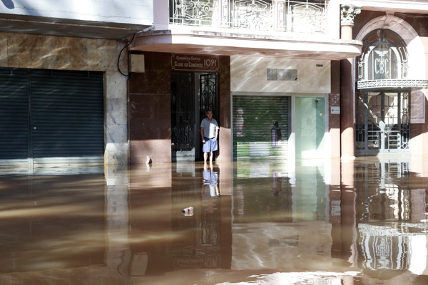 O taxista Paulo observa a rua inundada no centro histórico de Porto Alegre