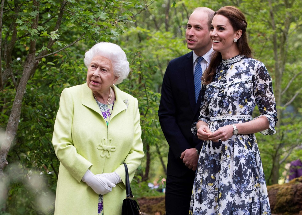 Rainha Elizabeth II acompanhada do neto, príncipe William, e de Kate Middleton — Foto: GEOFF PUGH / AFP