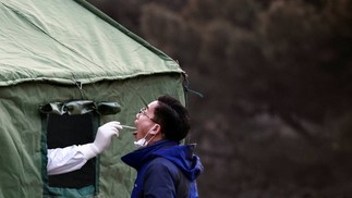 Homem faz um teste de ácido nucléico em um local improvisado de teste em um parque após um surto da COVID-19, em Pequim, China — Foto: THOMAS PETER / REUTERS