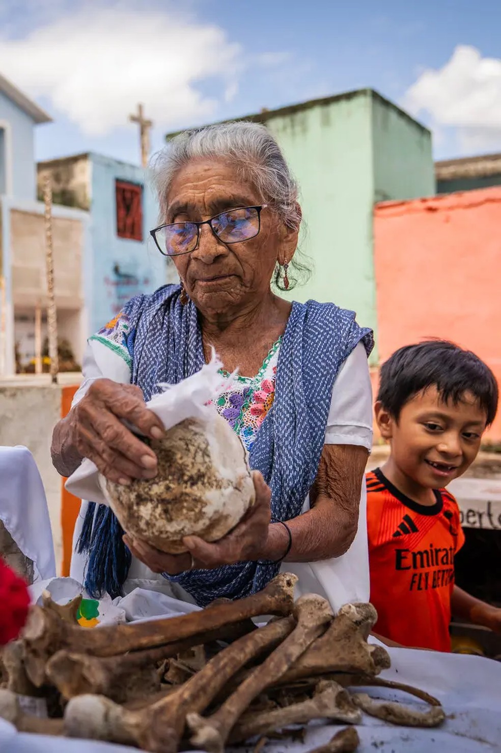 Maria Eredina Has Colli limpando os ossos de seu falecido marido — Foto: The New York Times