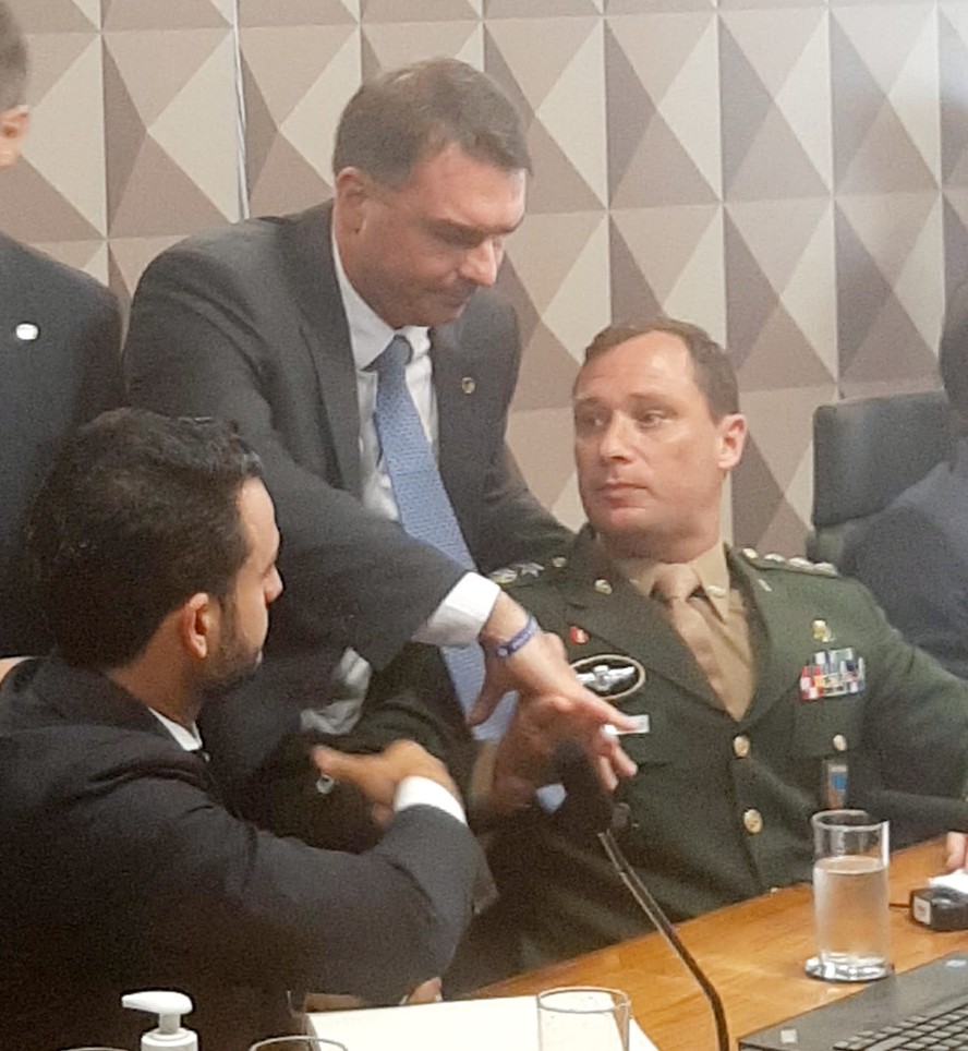 O senador Flávio Bolsonaro cumprimenta Mauro Cid na CPI do 8 de janeiro