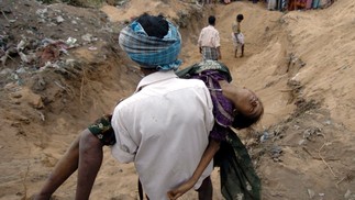 Homem carrega o corpo da filha em Cuddalore, na Índia, em 27 de dezembro de 2004 — Foto: Prakash Singh / AFP