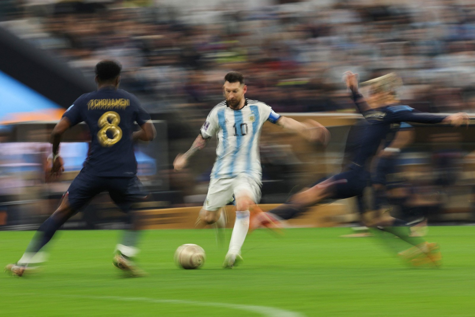 Messi controla a bola enquanto é marcado pelo meio-campista francês Aurelien Tchouameni — Foto: Adrian DENNIS / AFP