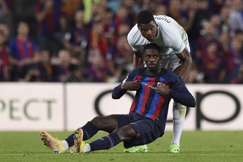 Dumfries ajuda Dembelé a se levantar em Barcelona x Inter de Milão em 2012. Jogadores se reencontrarão na final da Liga dos Campeões — Foto: JOSEP LAGO / AFP