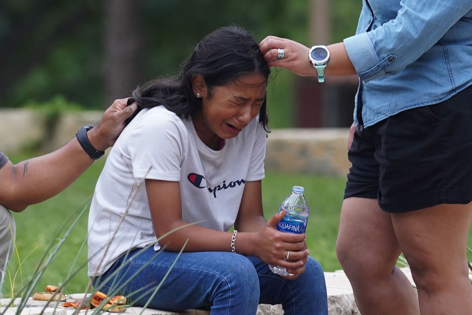 Menina é consolada no Centro Cívico Willie de Leon, em Uvalde, Texas, EUA. Atirador de 18 anos armado matou 18 crianças em uma escola primária próximo a uma comunidade latina, a uma hora da fronteira com o México — Foto: ALLISON DINNER / AFP