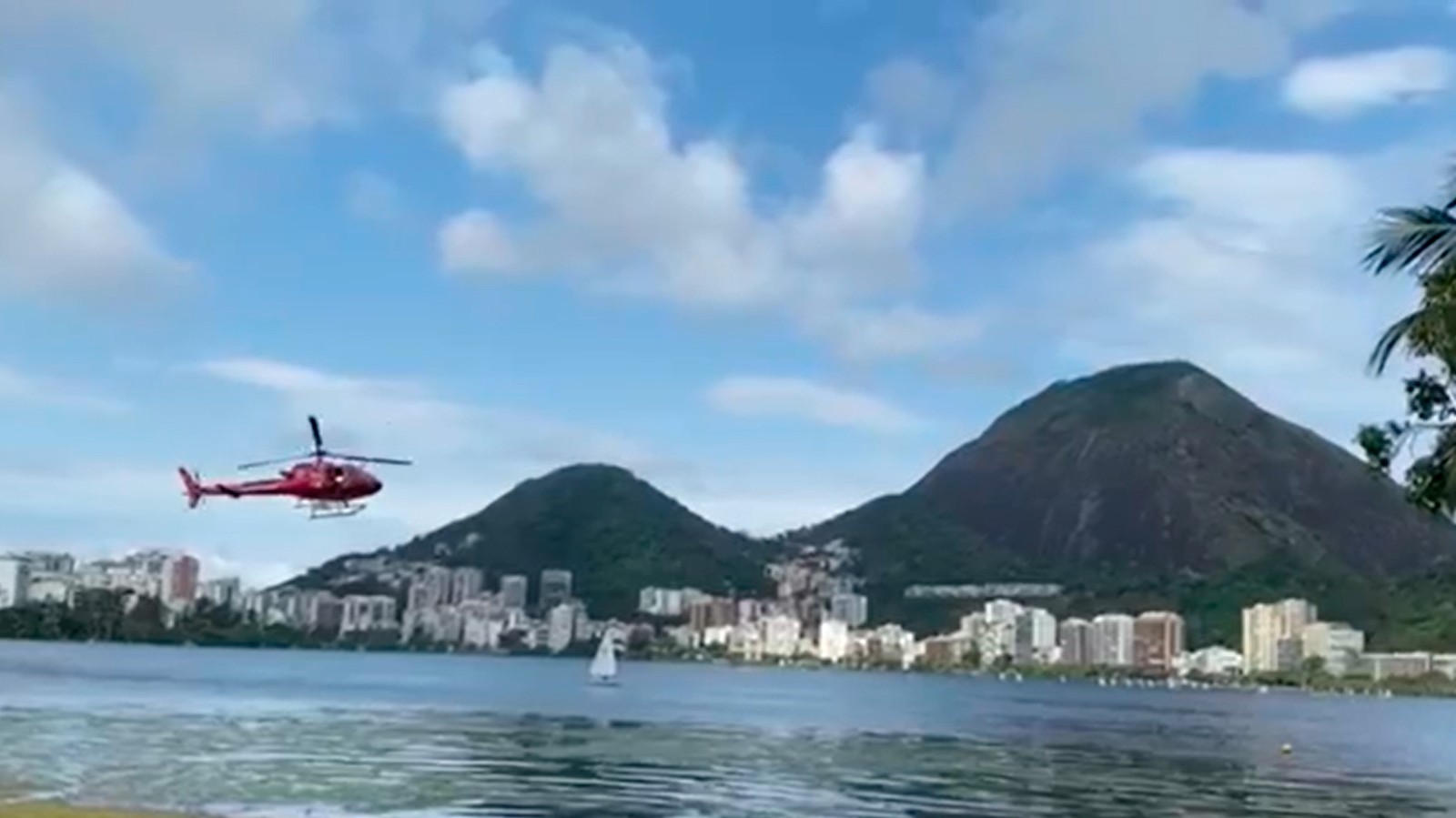 Aeronave dos Bombeiros sobrevoa a Lagoa Rodrigo de Freitas após um helicóptero cai no espelho d'água no início da tarde deste sábado. — Foto: Reprodução