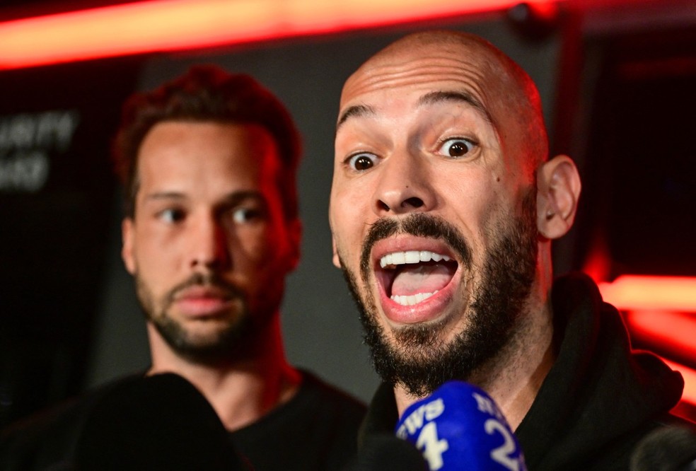 Os irmãos Andrew Tate (à dir.) e Tristan durante entrevista a jornalistas — Foto: AFP