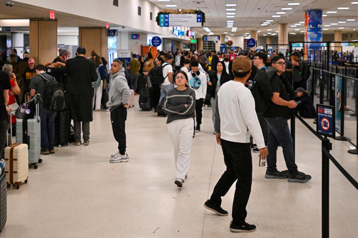 Passageiros aguardam no Aeroporto Internacional Luis Muñoz Marín, em Carolina, Porto Rico, após o cancelamento de todos os voos em decorrência dos ataques dos Estados Unidos na Venezuela. — Foto: Miguel J. Rodriguez Carrillo / AFP