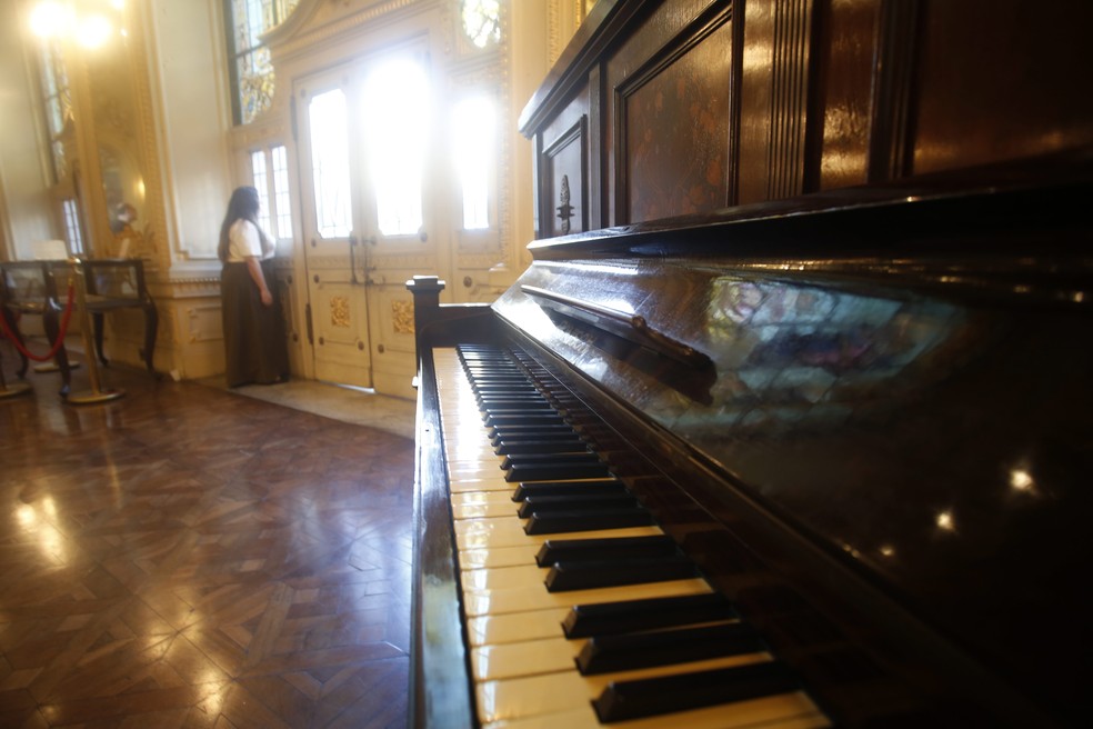 A chefe de gabinete Bárbara Ottero olha pela janela do salão onde fica o piano de Chiquinha Gonzaga — Foto: Custódio Coimbra