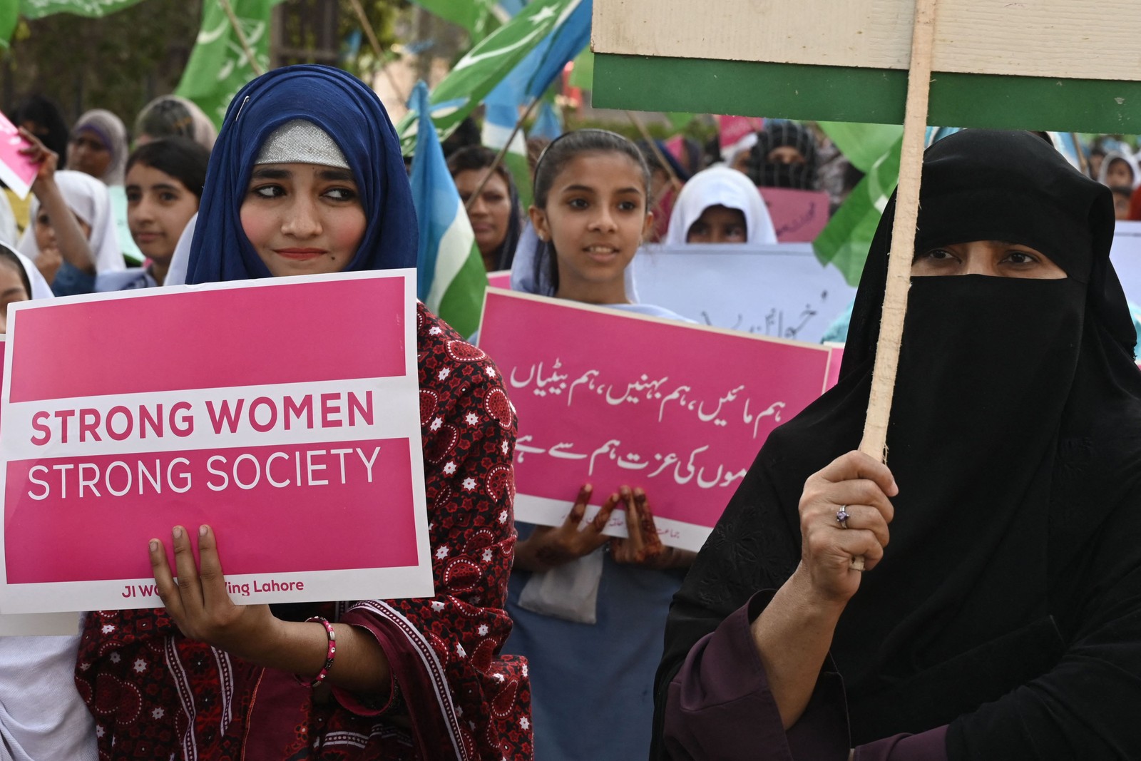 Ativistas do partido Jamaat-e-Islami (JI) seguram cartazes e bandeiras em manifestação pelo Dia Internacional da Mulher, em 2023, em Laore, no Paquistão — Foto: Arif Ali / AFP