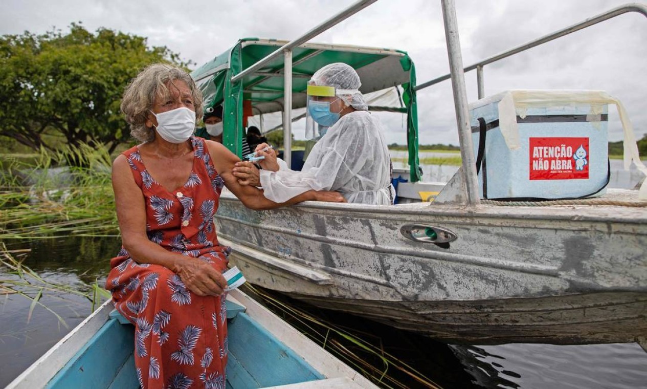 Olga D'arc Pimentel, 72 anos, é vacinada contra Covid-19, na comunidade Nossa Senhora Livramento, às margens do Rio Negro, perto de Manaus, Amazonas — Foto: MICHAEL DANTAS / AFP