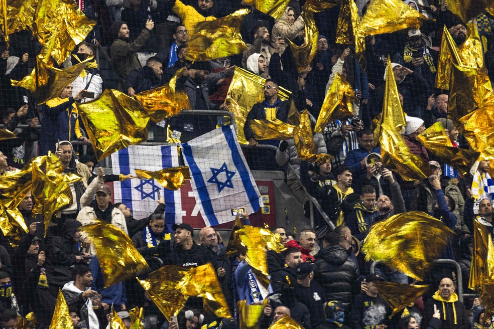 Torcedores do Maccabi Tel Aviv erguem bandeiras de Israel durante partida contra o Ajax pela Liga Europa &mdash; Foto: Robin van Lonkhuijsen / ANP / AFP