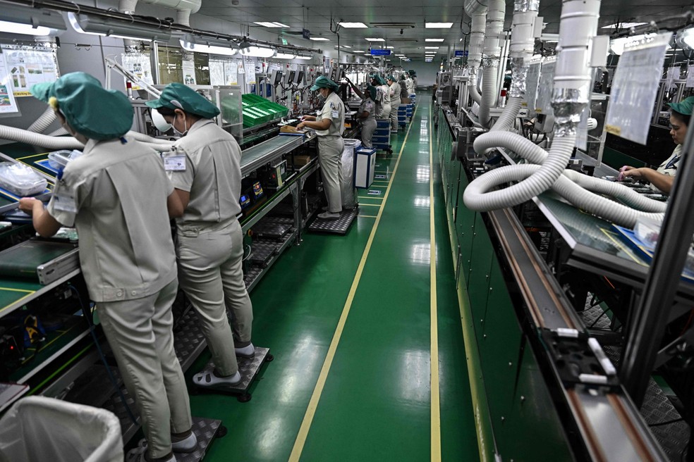 Trabalhadores montam calculadoras da Casio em uma fábrica na Tailândia — Foto: Lillian Suwanrumpha/AFP