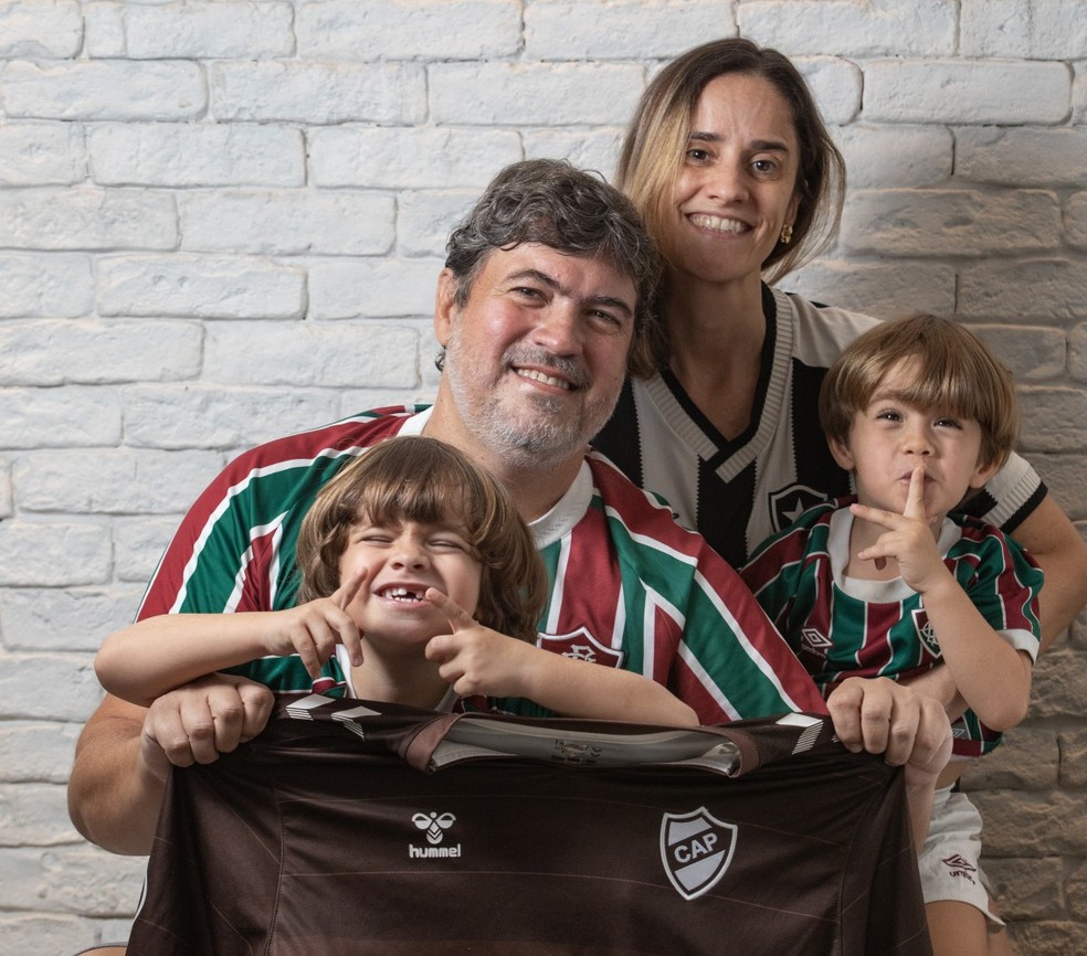 Emiliano Tolivia e os filhos, Miguel e Julio, torcem pelo Fluminense e seguram a camisa do Platense, enquanto a mãe, Marina, é botafoguense — Foto: Ana Branco