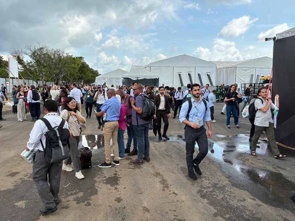 Pessoas do lado de fora da COP30 após incêndio ter início na conferência climática — Foto: Rafael Garcia