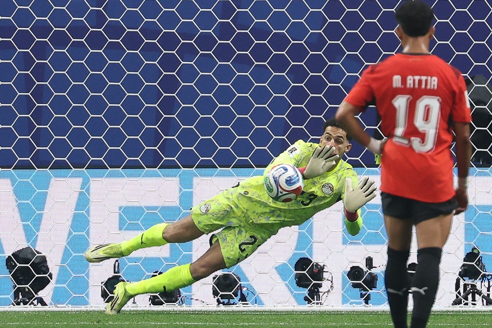 O goleiro eg&iacute;pcio n&ordm; 23, Mostafa Shoubir, defende uma cobran&ccedil;a de p&ecirc;nalti do atacante argentino n&ordm; 10, Lionel Messi, durante a partida das oitavas de final da Copa do Mundo de 2026 entre Argentina e Egito &mdash; Foto: ODD ANDERSEN / AFP