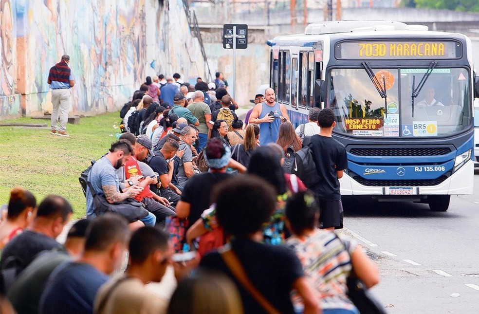 Ponto lotado. Passageiros esperam por seus ônibus: 204 linhas foram afetadas e mais de setenta coletivos foram usados como barricadas após a megaoperação — Foto: Marcelo Theobald