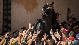 Cavalo empina no meio da multidão durante tradicional festival de São João, na cidade de Ciutadella, nas Ilhas Baleares de Minorca, Espanha — Foto: JAIME REINA / AFP