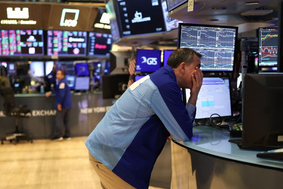 Operador na bolsa de Nova York (NYSE), acompanha a queda nas Bolsas após anúncio de tarifaço pelos EUA — Foto: TIMOTHY A. CLARY / AFP