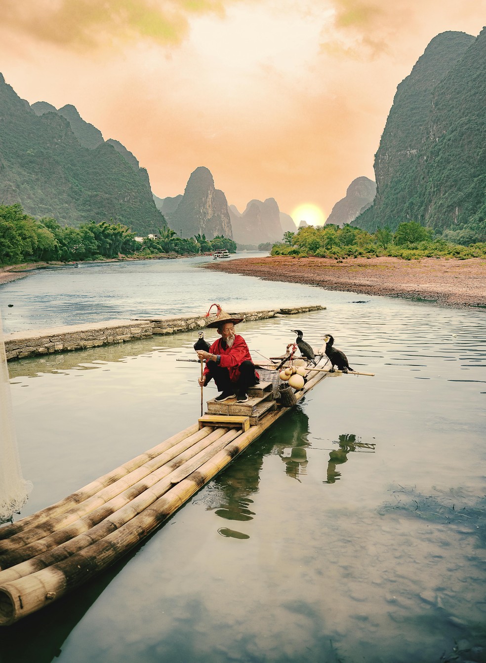 Pescador em seu barco tradicional na região rural de Guilin, um dos municípios mais bonitos da China — Foto: Reprodução/Fabrizio Soldano/Pexels