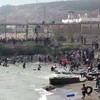 Esta imagem capturada de um vídeo da AFP mostra migrantes chegando à costa de Ceuta — um enclave espanhol no norte da África — após nadarem ao redor da cerca fronteiriça entre o Marrocos e a Espanha, em 30 de julho de 2026 - LUCIA DIAZ / AFP