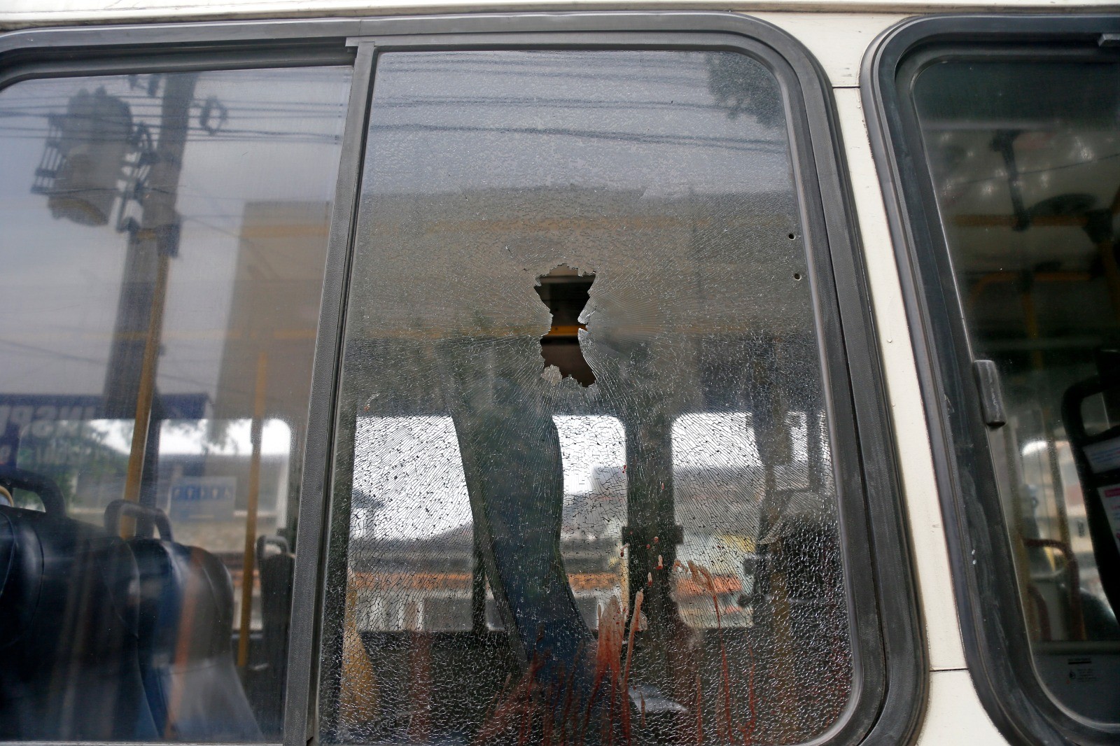 Devido a uma operação policial no Complexo de Israel, na Zona Norte, nesta quinta-feira, uma parte da Avenida Brasil se encontra fechada. Na foto, marca de tiro na janela do ônibus da linha 493 onde um homem foi baleado. — Foto: Fabiano Rocha / Agência O Globo