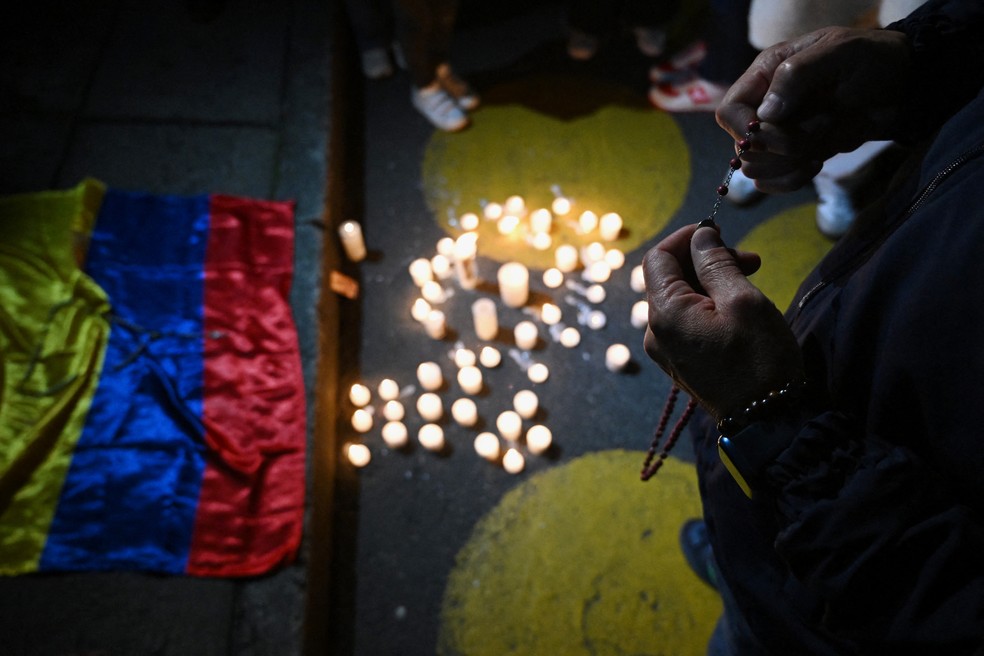 Pessoas esperam do lado de fora da Clínica Fundación Santa Fe, onde o senador Miguel Uribe Turbay está recebendo tratamento médico — Foto: AFP