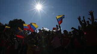 Venezuelanos agitam bandeiras nacionais enquanto participam de uma marcha no Dia Internacional da Juventude em Caracas — Foto: FEDERICO PARRA/AFP