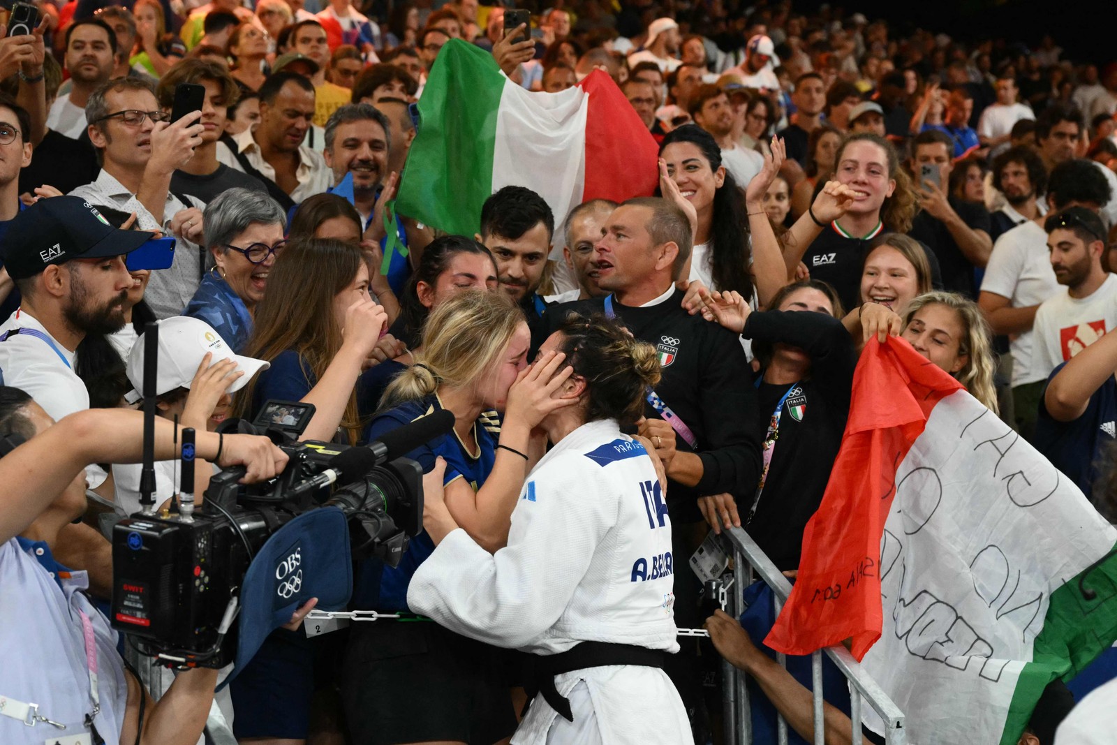 Gold in judo, Italian Alice Bellandi celebrates by kissing her girlfriend, Jasmine Martin — Photo: Luis ROBAYO / AFP