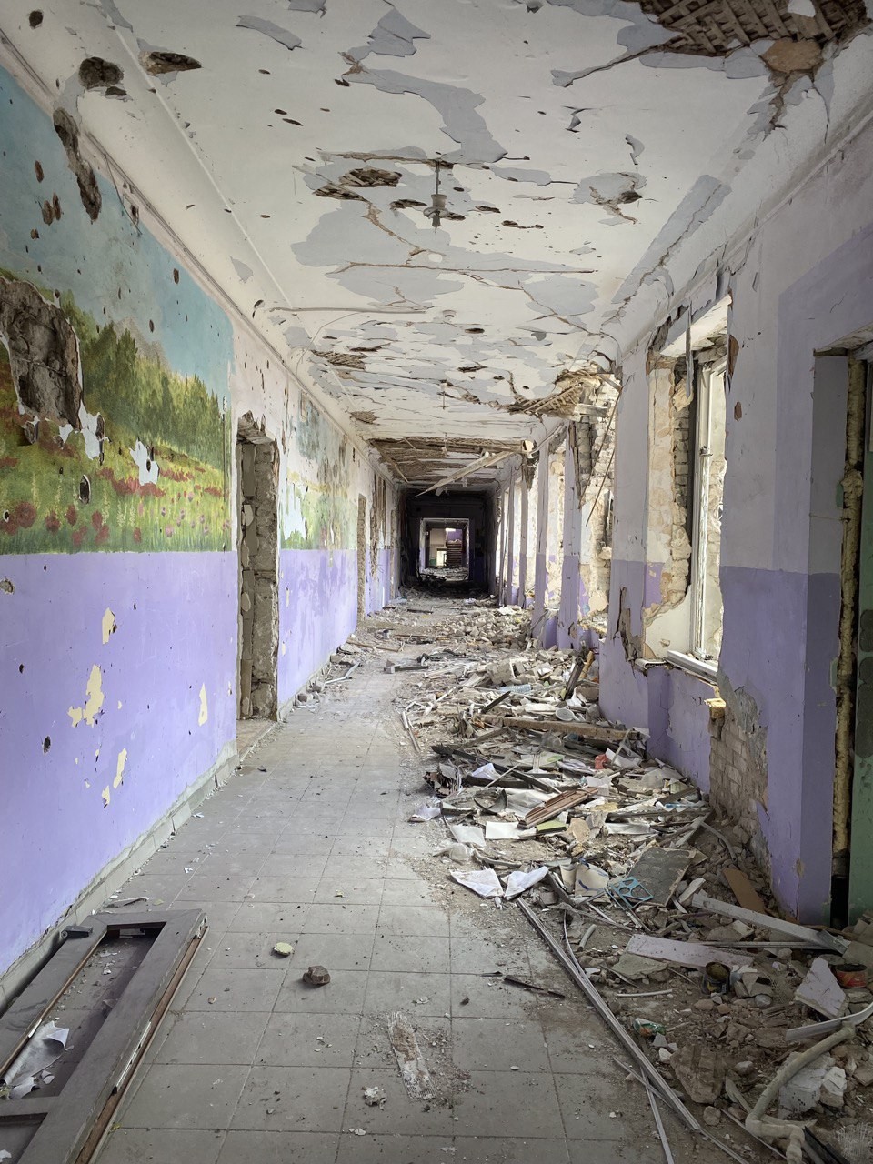 A pintura na parede da escola destruída pela guerra mostra que num passado pouco distante o local era repleto de vida — Foto: Ekaterina Diachkova