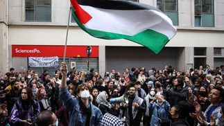 Manifestante agita bandeira palestina durante manifestação em frente ao Instituto de Estudos Políticos (Sciences Po Paris) ocupado por estudantes, em apoio aos palestinos, em Paris — Foto: Antonin UTZ / AFP