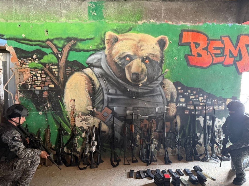 Parte da apreensão de fuzis na operação. Grafite faz alusão a um urso, vulgo do traficante  Edgard Alves de Andrade, o Doca, chefe do CV — Foto: Reprodução