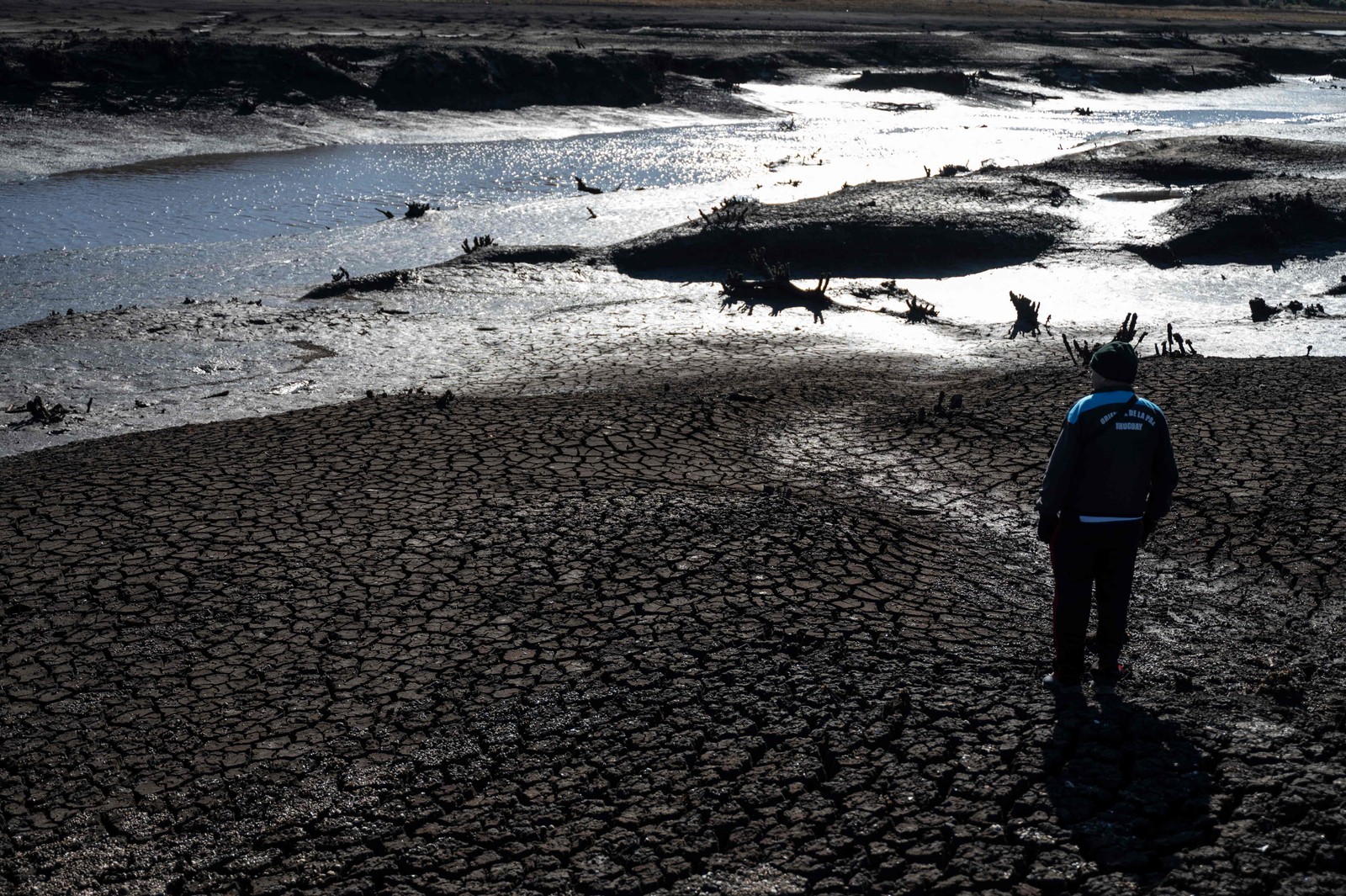 Um morador observa o baixo nível da água e a terra rachada do reservatório Paso Severino — Foto: Eitan ABRAMOVICH / AFP