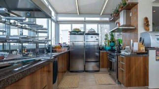 A cozinha do apartamento tem armários de madeira — Foto: Reprodução