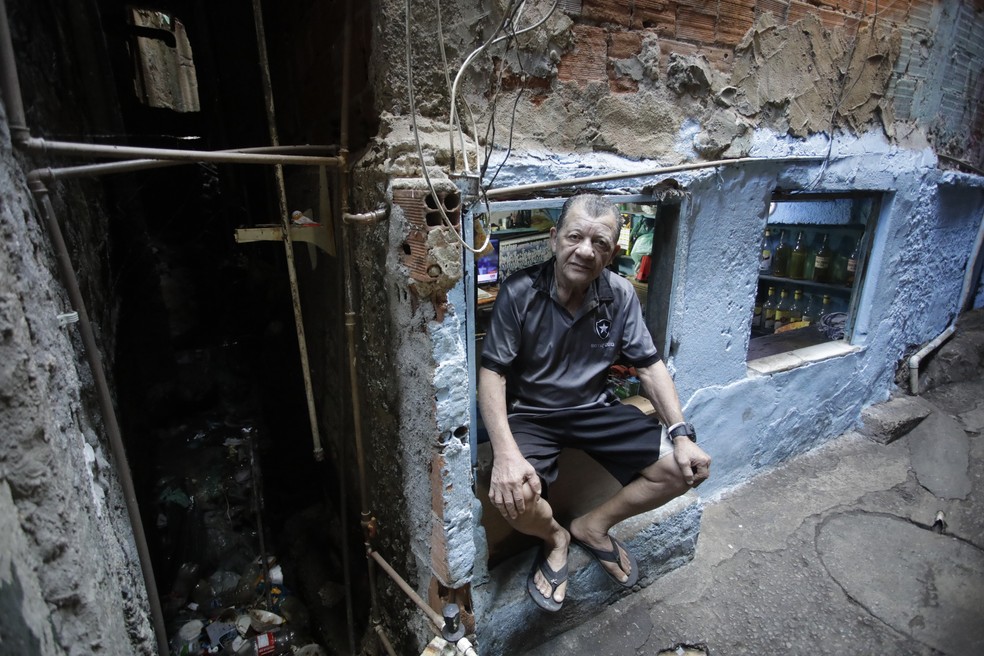 Condições insalubres. Jurandir Antônio, de 72 anos, vive ao lado de uma vala: em dias de chuva forte, diz ele, a água invade sua birosca e chega à altura do joelho — Foto: Fabiano Rocha