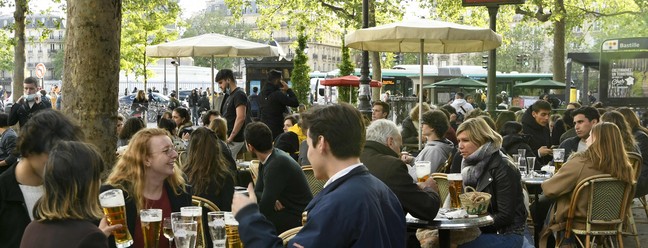 Turistas e moradores aproveitam o ar livre em Paris, na França, depois que o governo suspendou parte das medidas de restrição contra a Covid-19AFP