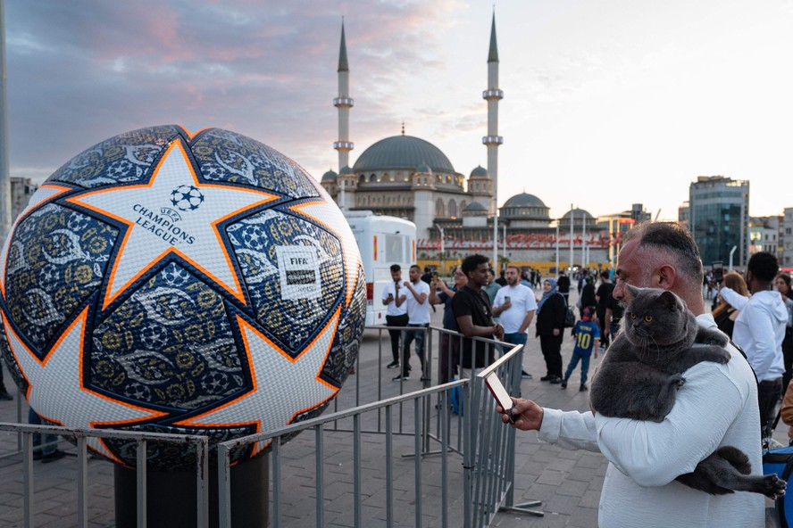 Homem fotografa bola gigante da Champions na Praça Taksim, em Istambul