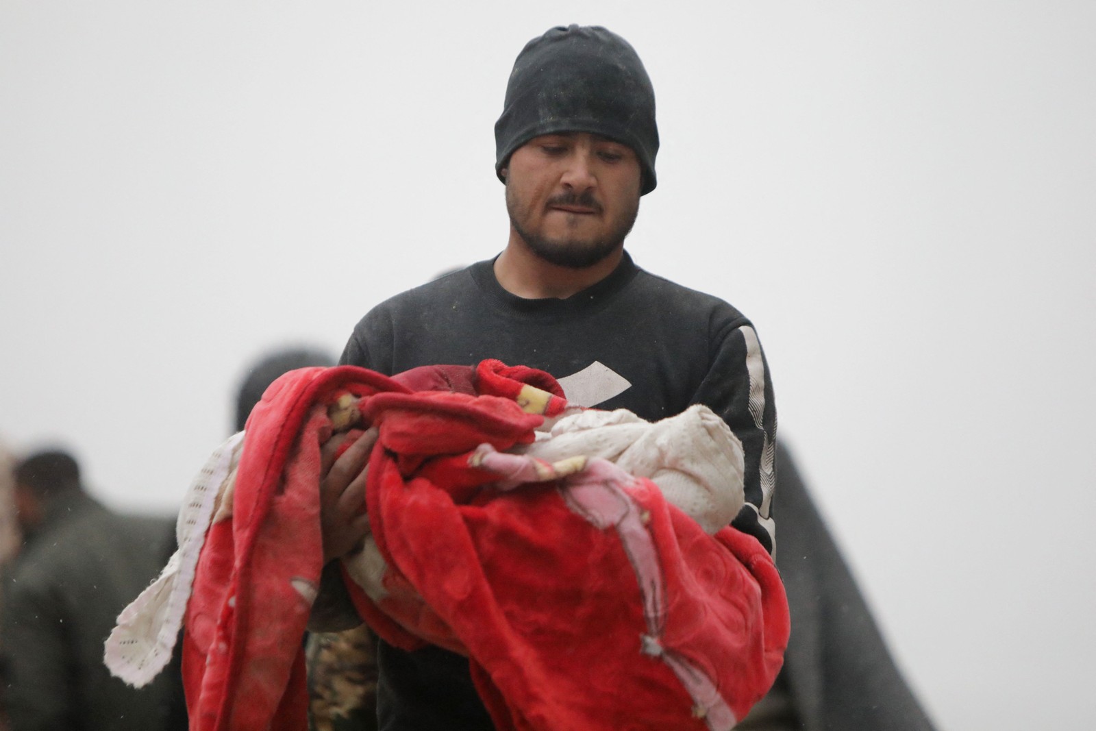 Homem carrega corpo de criança que foi morta em um terremoto na Síria em 6 de fevereiro de 2023 — Foto: Bakr Alkasem / AFP