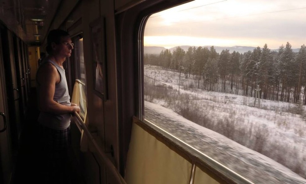 Passageiro observa a paisagem no trem da Transiberiana: viagem é imersão na paisagem e cultura russas — Foto: Juarez Becoza
