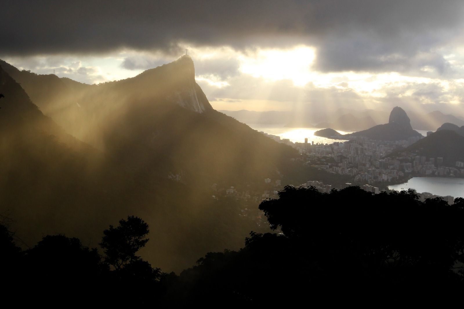 Raios solares escapam de nuvens e iluminam cidade do Rio, diante do Cristo Redentor, na primavera de 2010 — Foto: Custódio Coimbra