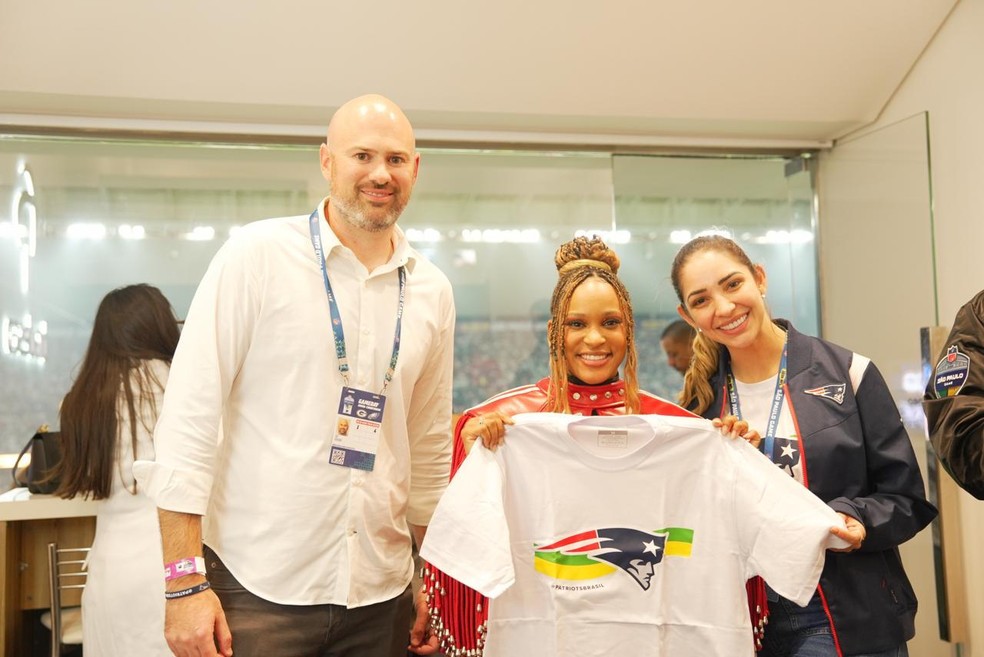Representantes dos Patriots, Joe Dorant (à esquerda) e Lara Magalhães (à direita) com a ginasta Rebeca Andrade, em São Paulo — Foto: Divulgação