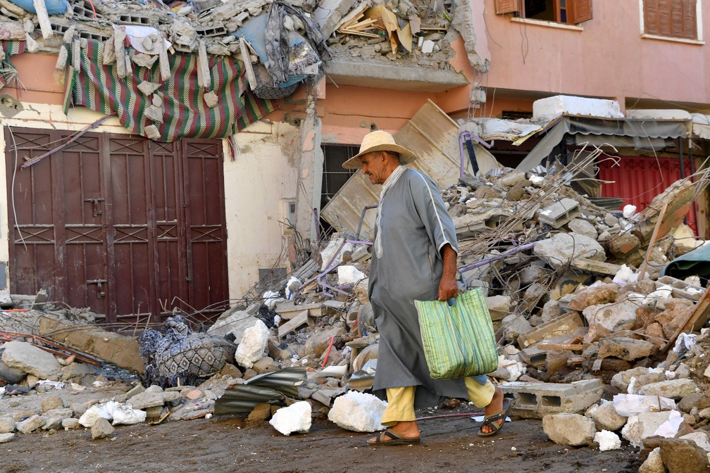 Morador caminha pelos escombros de um edifício na aldeia de Mzouda, na província de Chichaoua — Foto: Fethi Belaid/AFP