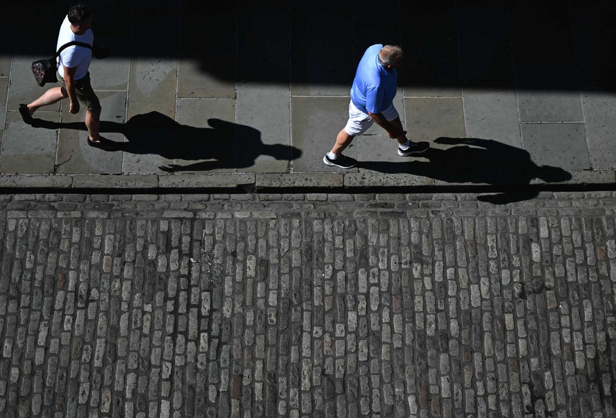 Pessoas caminham na rua em Guidford, no Reino Unido, onde as temperaturas bateram os 36ºC em meio a onda de calor