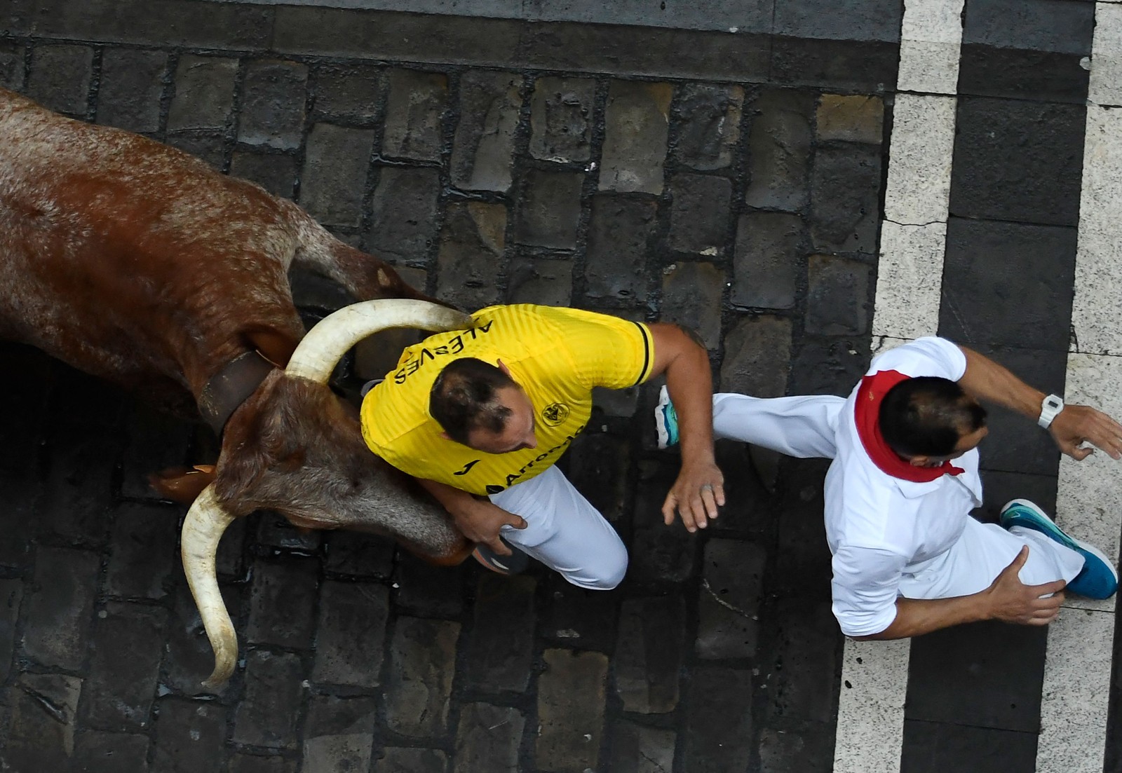 Participantes fogem de touro pelas ruas de Pomplona, Espanha — Foto: ANDER GILLENEA / AFP