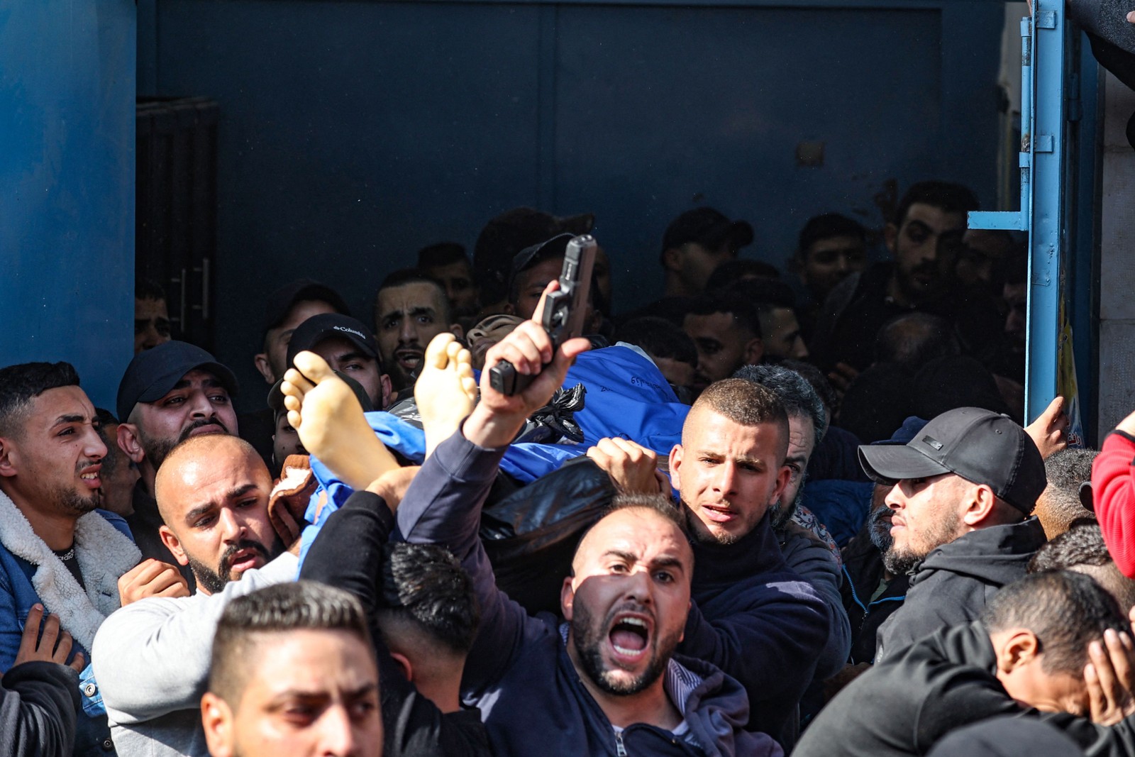 Revoltado, homem dá tiros para o alto durante velório de uma das 9 vítimas relatadas mortas durante um ataque israelense no campo de refugiados de Jenin, na Cisjordânia — Foto: JAAFAR ASHTIYEH/AFP