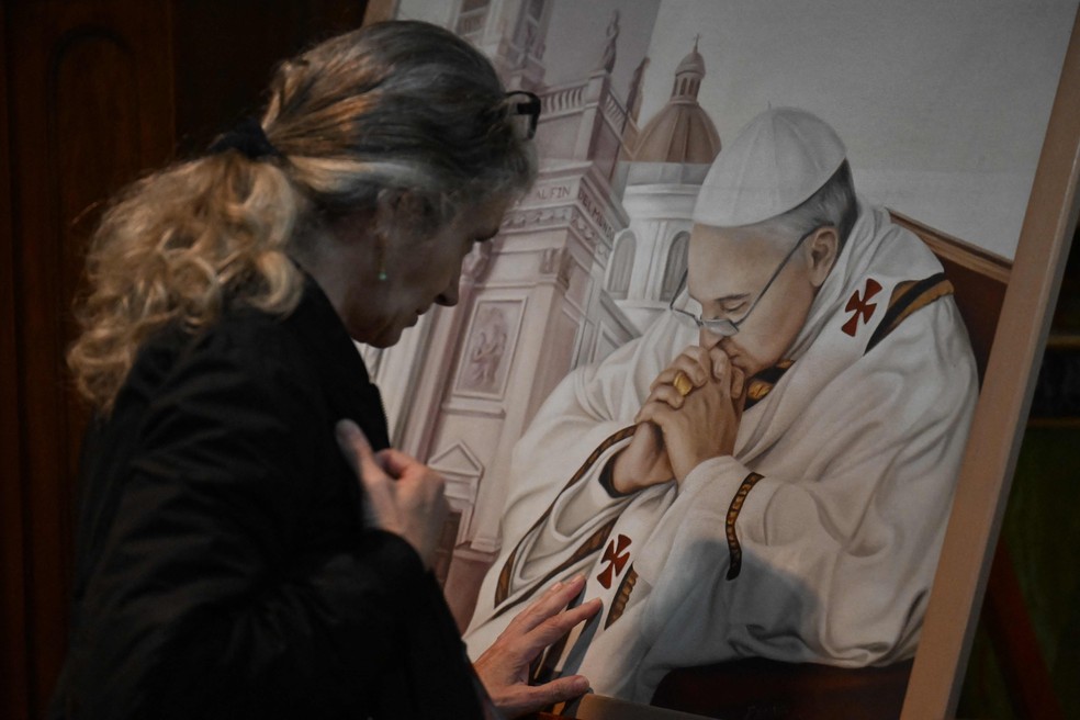 Uma fiel reza na Basílica San José de Flores, em Buenos Aires, em 21 de abril de 2025, após a morte do Papa Francisco no Vaticano. — Foto: Luis Robayo / AFP