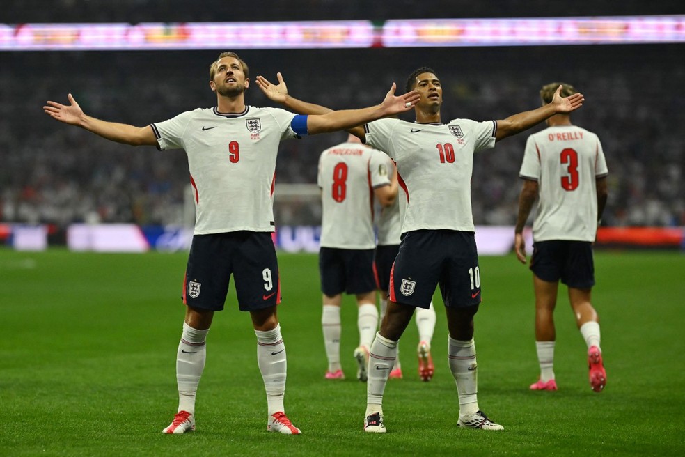 O meio-campista inglês número 10, Jude Bellingham, comemora o primeiro gol de sua equipe com o atacante inglês número 9, Harry Kane — Foto: ALFREDO ESTRELLA/AFP