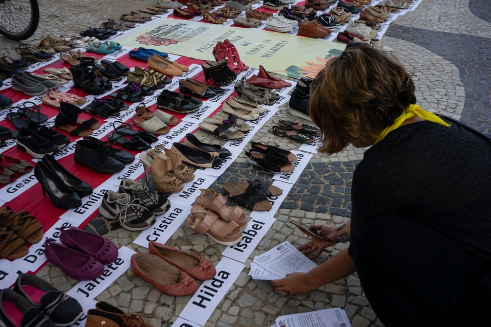 Em Copacabana, sapatos representam as mulheres mortas por feminicídio em 2022 e 2023 — Foto: Tércio Teixeira/AFP
