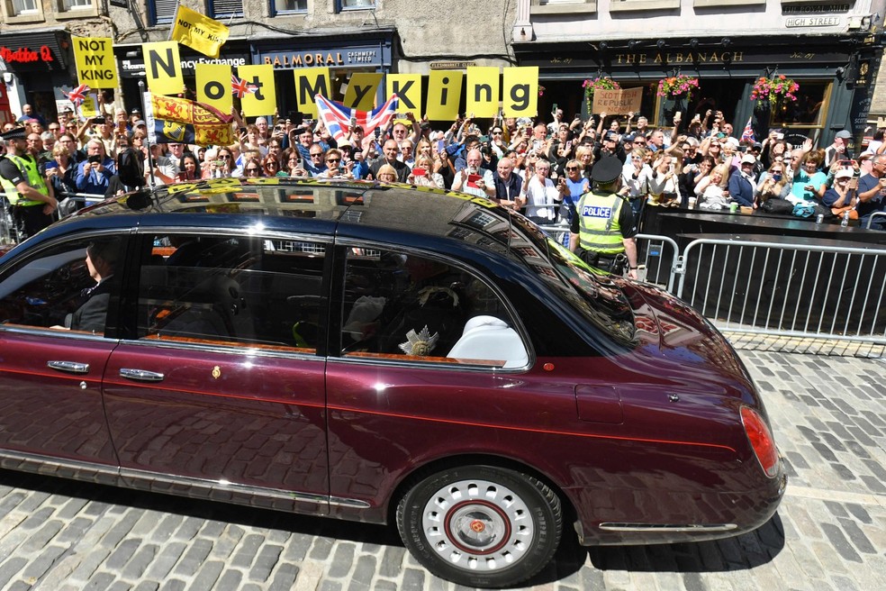 Manifestantes brandindo cartazes contra o rei Charles III, na Escócia — Foto: Mark Runnacles / AFP